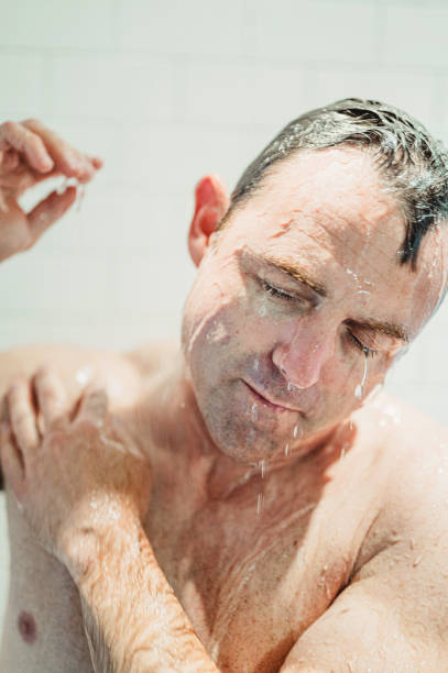 istock Middle age fit man getting wet, taking a shower or bathing 1391331785