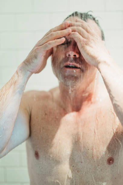 istock Middle age fit man getting wet, taking a shower or bathing 1391331793