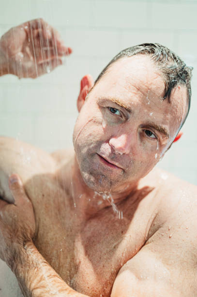 istock Middle age fit man getting wet, taking a shower or bathing 1391331794
