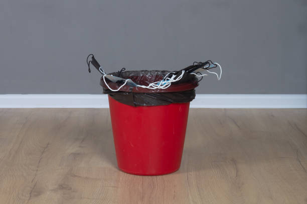istock Medical protective new unused masks thrown into a red trash can 1391333022