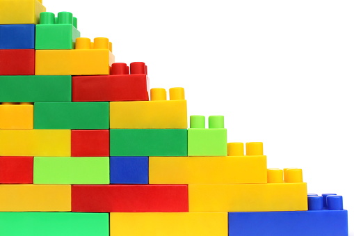 Bright multi-colored cubes of the designer scattered lie on a white isolated background.