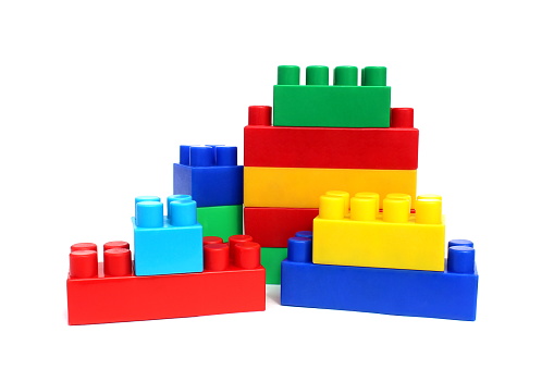 Bright multi-colored cubes of the designer scattered lie on a white isolated background.