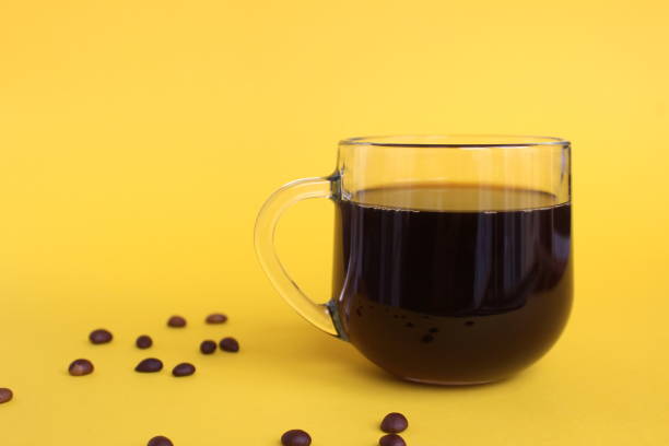 istock Glass cup with black coffee on a yellow background 1391336381