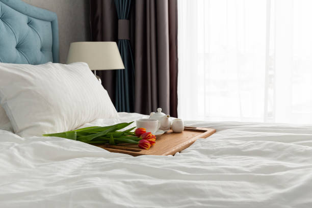 istock Breakfast in bed on a wooden table tray. light from the window. Flowers 1391337501