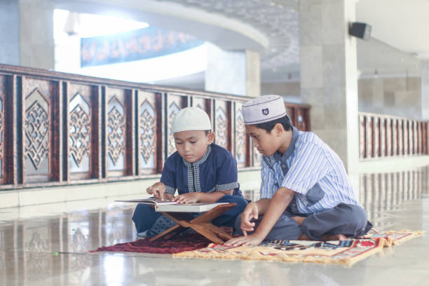 Muslim boys with his brother recite the Koran in the mosque
