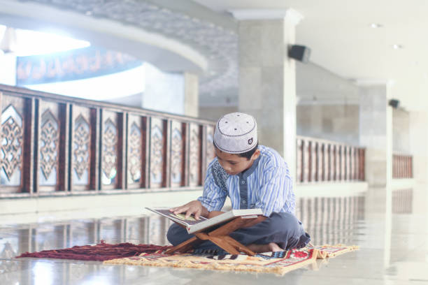 Muslim boys with his brother recite the Koran in the mosque