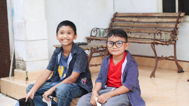 child boy sitting in front of house
