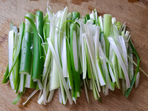 For cooking, wild garlic leaves are finely chopped. Fresh wild garlic closeup on a kitchen board