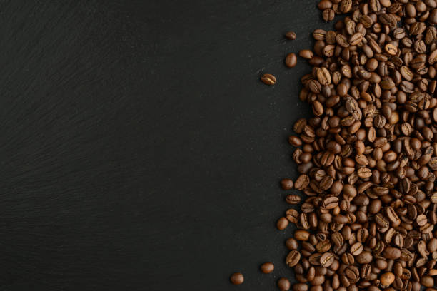 istock Coffee beans on black stone background. Roasted Coffee beans texture, top view, copy space 1391347423