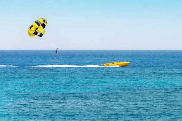 Photo of Parasailing above the ocean with copy space, holiday fun activities.