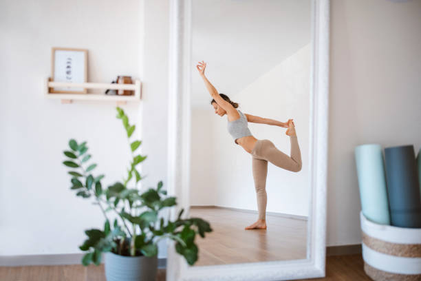 istock Woman in a mirror reflection stretching before yoga class. 1391348261