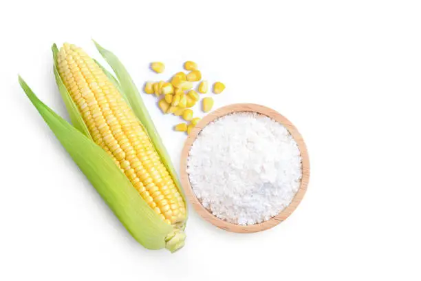 Corn starch in wooden bowl and fresh sweet corn with kernels isolated on white background. Top view. Flat lay.