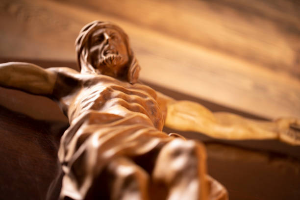Cruciefied Jesus figure isolated on wooden brown background.