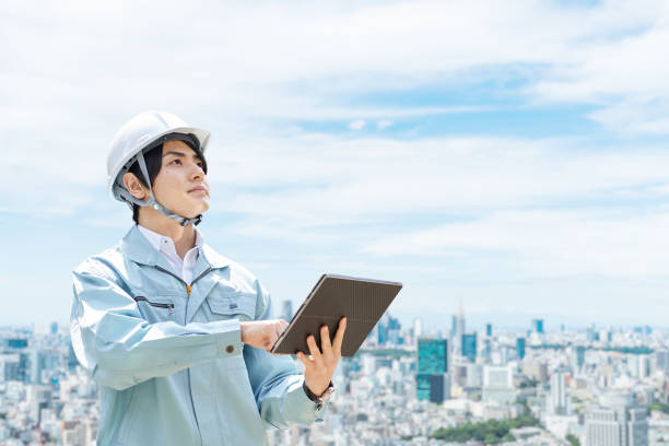 trabajadores de la construcción en el contexto de la ciudad - overalls fotografías e imágenes de stock