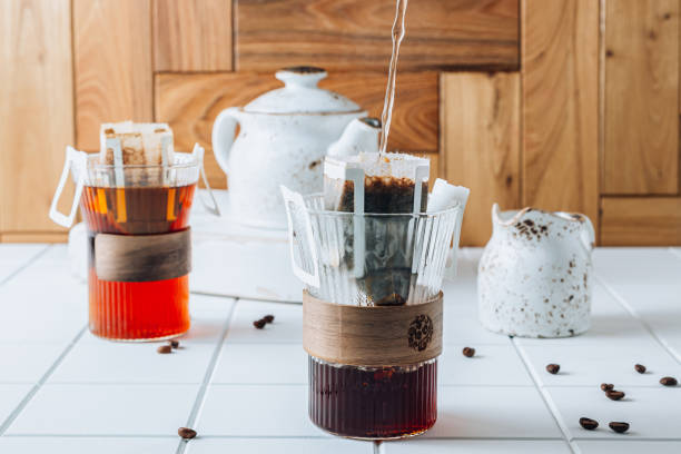 istock Ground drip coffee using paper type filter with coffee beans on white ceramic tiles background 1391354046