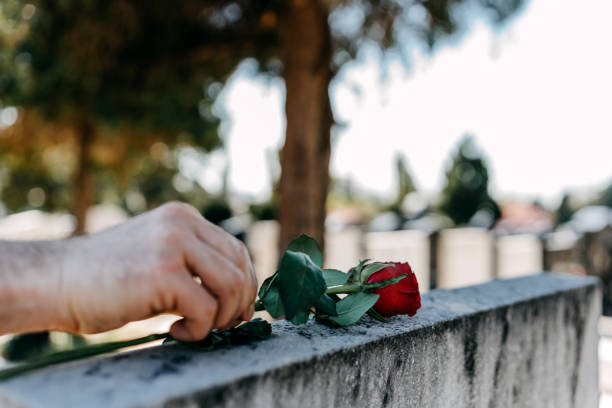 istock Man Laying Flowers On Grave 1391355920