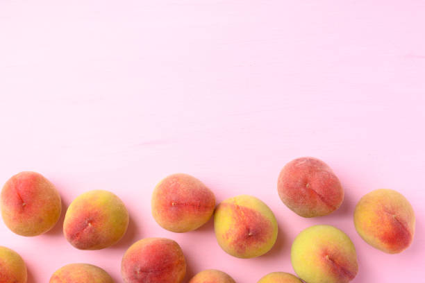 Peach fruit on pink background