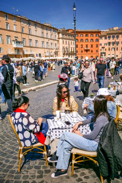 젊은 관광객들은 로마의 바로크 양식의 중심부에있는 나보나 광장 (piazza navona)의 카페에 앉아있는 삶을 즐깁니다. - piazza navona 뉴스 사진 이미지