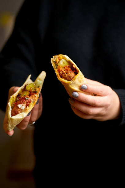 istock A girl is holding a kebab shawarma. Selective focus 1391363149