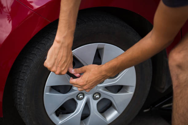 istock Man repairing car wheel on the road. 1391364507