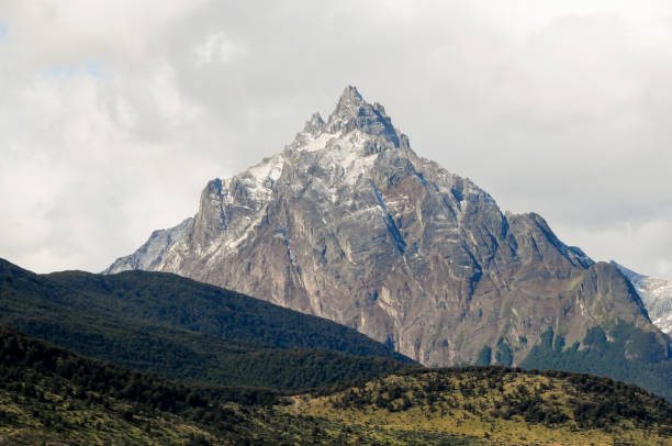 istock Mountain peaks covered with snow and hills with grass and vegetation 1391364826