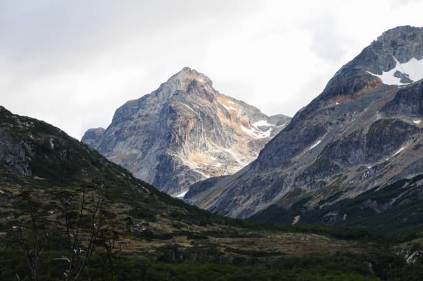 istock Mountain peaks covered with snow and hills with grass and vegetation 1391365539