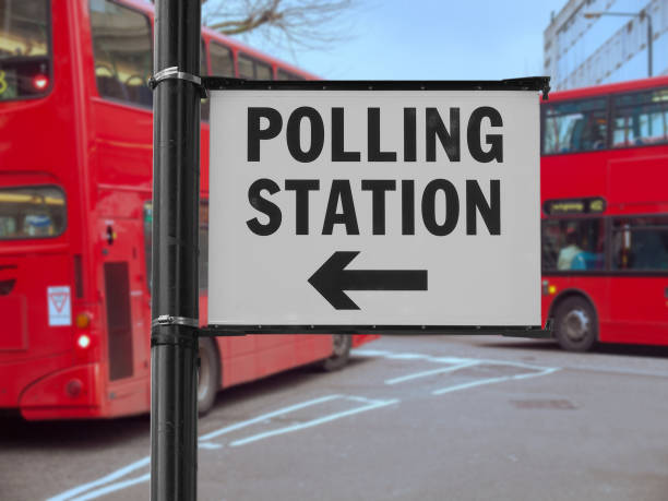 istock Polling station sign over blurred double decker bus background 1391369162
