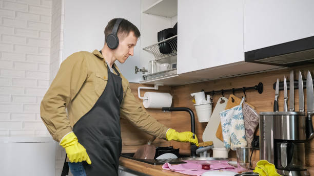 hombre lava platos bailando y escuchando música en auriculares - all laundry detergent audio fotografías e imágenes de stock