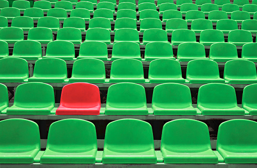 Background of empty seats in a stadium with one special