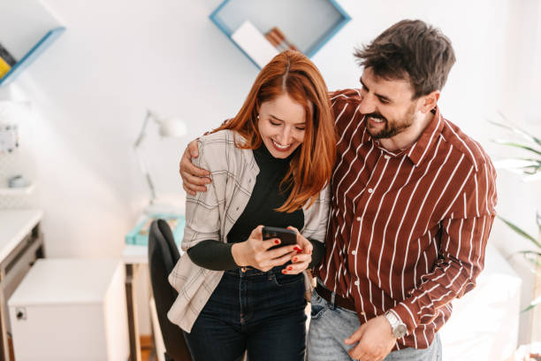 istock Colleagues hugging and looking at the phone in co-working space 1391371680