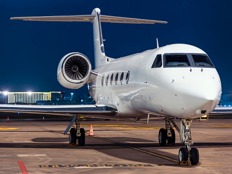 Corporate jet parked at airport at night