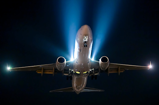 Night picture of aircraft approaching airport runway for landing with visible lights