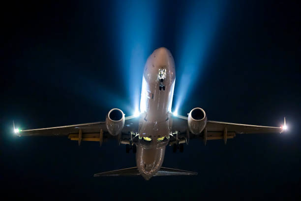Aircraft flying at night stock photo