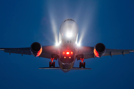 Night picture of aircraft approaching for landing with visible lights