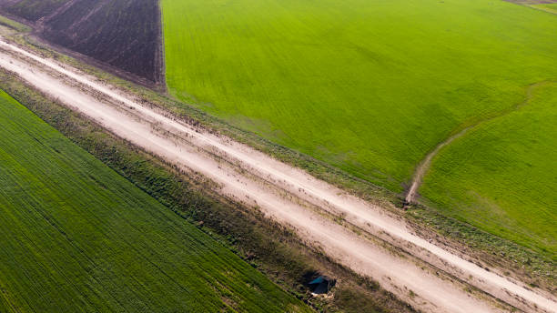 kuvapankkikuvat ja rojaltivapaat kuvat aiheesta tie, joka jakaa vihreän kentän dronella nähtynä - wood grain