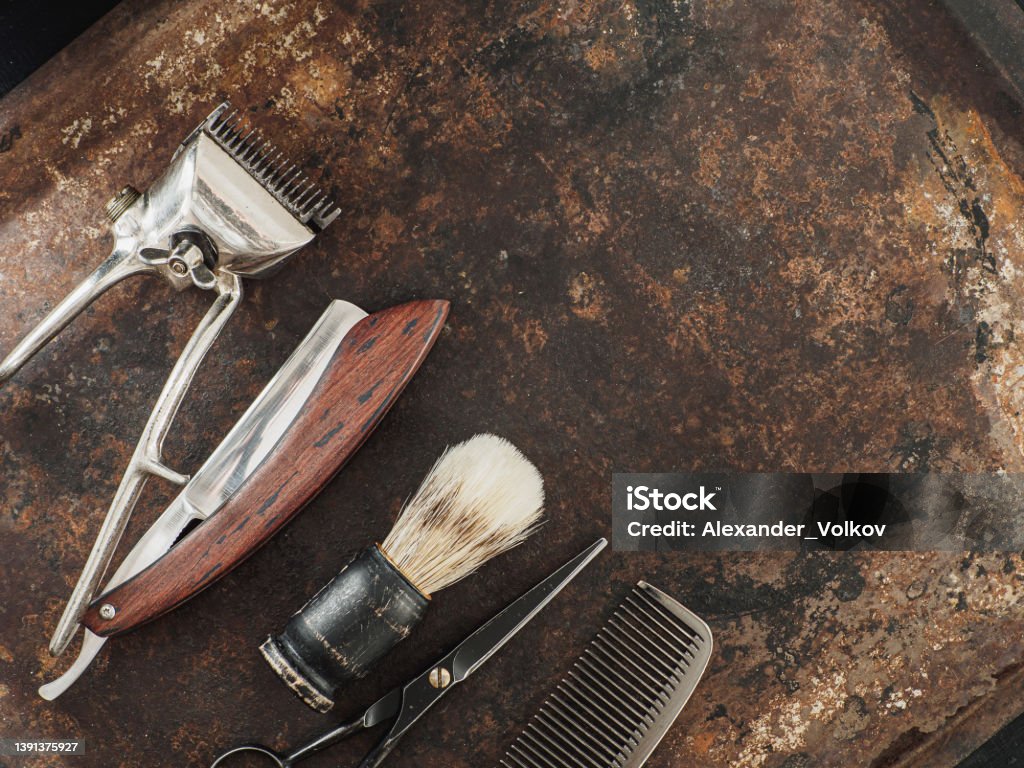 vintage barber tools: dangerous razor, hairdressing scissors, old manual clipper, comb, shaving brush vintage barber tools: dangerous razor, hairdressing scissors, old manual clipper, comb, shaving brush placed on rusty background. top view flat lay. copy space Barber Shop Stock Photo