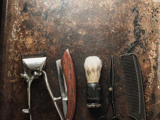 istock vintage barber tools: dangerous razor, hairdressing scissors, old manual clipper, comb, shaving brush 1391376200