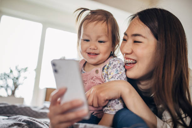 istock Mother and daughter lying on the bed and using smart phone 1391376328