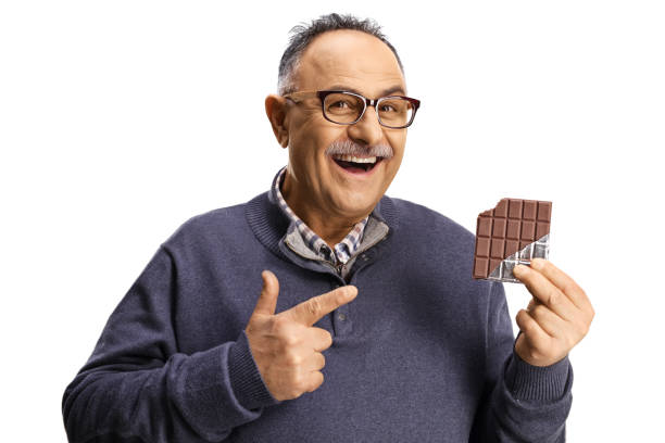 istock Mature man holding a chocolate bar and pointing 1391378970
