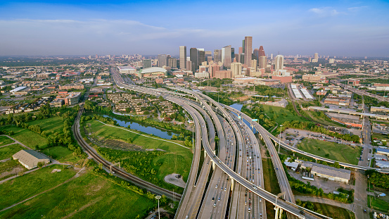 Aerial view of cars moving on freeway passing Downtown Houston seen in the background, Texas, USA.