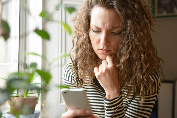 Stressed Looking at Smartphone Screen stock photo