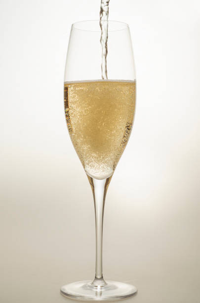 champagne bubbles of different shapes in a special one-piece champagne glass when pouring on a light background in the studio stock photo