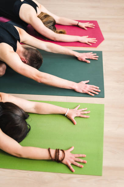 istock Group of young adults stretching on exercise mat 1391382593