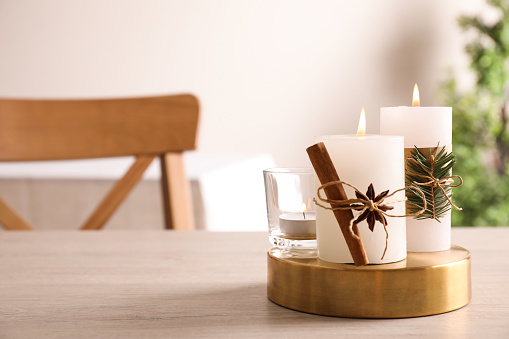 Decorated scented candles on table indoors, space for text