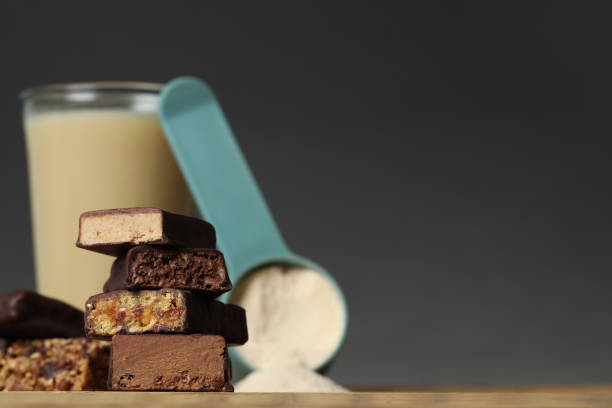 istock Different energy bars, protein cocktail and powder on wooden table, closeup. Space for text 1391392579