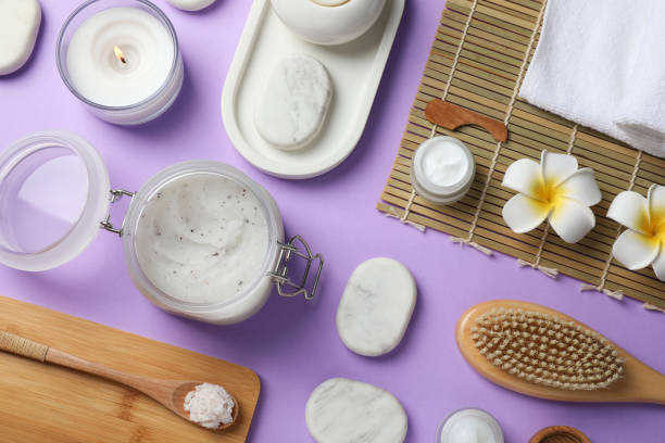 istock Flat lay composition with body scrub and spa stones on violet background 1391392647