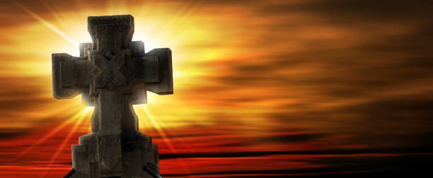 istock Old Stone Religious Cross against a Beautiful Sunset with Sunbeams 1391393665