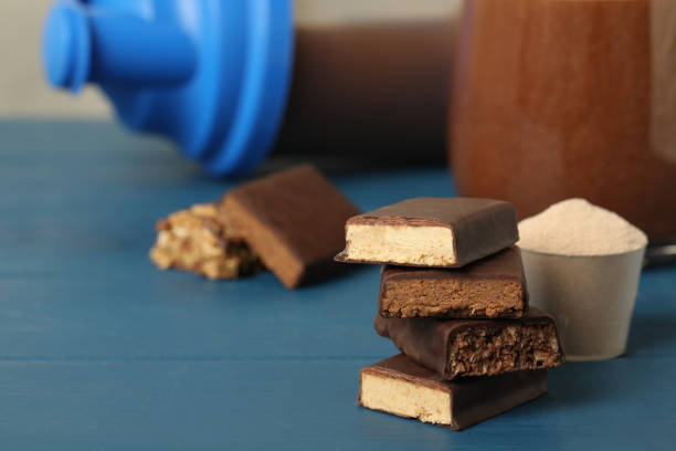 istock Different energy bars, protein cocktail and powder on blue wooden table. Space for text 1391393765