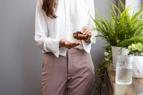 femme prenant un comprimé avec un verre d’eau douce. - prozac photos et images de collection