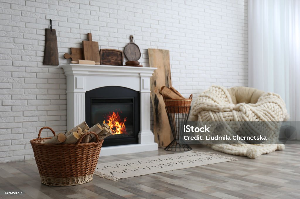 Wicker baskets with firewood and white fireplace in cozy living room Fireplace Stock Photo